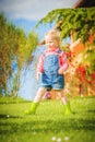 Marvelous little girl plays with on green spring grass