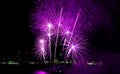 Marvelous purple pink fireworks exploding into the night sky over the city