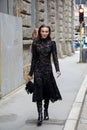 Mary Leest with black embroidered dress and bag walking before Ermanno Scervino fashion show,