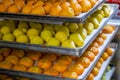 Marzipan fruits assortment. Close up of marzipan sweets shaped and painted as orange and pear in patisserie shop