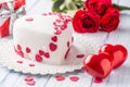 Marzipan white cake in the shape of a heart with red hearts. As the decoration bouquet of red roses a gift from the ribbon. Royalty Free Stock Photo