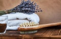 Masage brush, body skin care and coffee natural scrub in glass, white towel and bouquet of dry lavender on dark wooden background