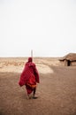 Masai or Maasai tribe man in red cloth in empty golden dusty land. Ngorongoro Consevation, Serengeti Savanna forest in Tanzania Royalty Free Stock Photo