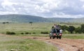 Through the Masai Mara National Park Jeep carries local African residents