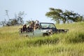 Masai scout and tourists look for animals from a Landcruiser during a game drive at the Lewa Wildlife Conservancy in North Kenya,