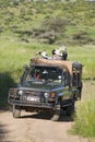 Masai scout and tourists look for animals from a Landcruiser during a game drive at the Lewa Wildlife Conservancy in North Kenya, Royalty Free Stock Photo