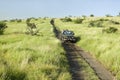 Masai scout and tourists look for animals from a Landcruiser during a game drive at the Lewa Wildlife Conservancy in North Kenya, Royalty Free Stock Photo