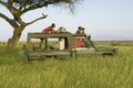 Masai scouts and tourist look for animals from a Landcruiser during a game drive at the Lewa Wildlife Conservancy in North Kenya,