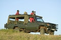 Masai scouts and tourist look for animals from a Landcruiser during a game drive at the Lewa Wildlife Conservancy in North Kenya,