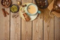 Masala chai tea traditional indian drink with milk and spices on wooden background. Top view from above