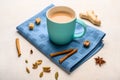 Traditional Indian masala tea chai with milk and spices on napkin on white background with ingredients above Royalty Free Stock Photo