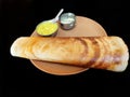 Masala dosa served with sambar and chutney in a brown plate