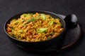 Masala Egg Bhurji or Muttai Podimas in black bowl on slate table top. Anda Bhurji is indian cuisine scrambled eggs dish