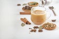 Masala tea in a glass cup and a natural mixture for its preparation - star anise, cinnamon sticks, cardamom, bay leaf, pepper Royalty Free Stock Photo