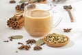 Masala tea in a glass cup and a natural mixture for its preparation - star anise, cinnamon sticks, cardamom, bay leaf Royalty Free Stock Photo