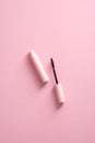 Mascara tube on pink background. Flat lay, top view. Makeup cosmetics concept