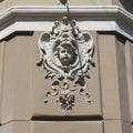 Mascaron in the form of a female head on the facade of a 19th-century house in the style of Vienna secession or Art Nouveau.