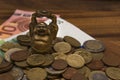 Mascot netske Hotei coins Euro banknotes on a wooden table Royalty Free Stock Photo