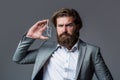 Masculine perfume, bearded man in a suit. Male holding up bottle of perfume. Man perfume, fragrance. Perfume or cologne Royalty Free Stock Photo