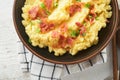 Mashed boiled potatoes. Bacon mashed potatoes with green onion, pepper and cheddar cheese in bowl on light old wooden backgrounds