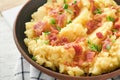 Mashed boiled potatoes. Bacon mashed potatoes with green onion, pepper and cheddar cheese in bowl on light old wooden backgrounds