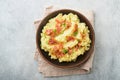 Mashed boiled potatoes. Bacon mashed potatoes with green onion, pepper and cheddar cheese in bowl on light old wooden backgrounds