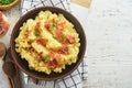 Mashed boiled potatoes. Bacon mashed potatoes with green onion, pepper and cheddar cheese in bowl on light old wooden backgrounds