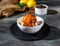 Mashed Potato with Brown Sauce with black pepper and lime in bowl side view on dark background