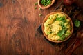 Mashed potato with butter, green peas, onions, basil on a rustic wooden background. Top view with close up