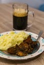 Mashed potato with pork meat made with spices and a mug of black beer Royalty Free Stock Photo