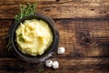 Mashed potatoes, boiled puree in cast iron pot on dark wooden rustic background, top view, copy space