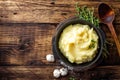 Mashed potatoes, boiled puree in cast iron pot on dark wooden rustic background, top view, copy space