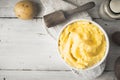 Mashed potatoes in the bowl on the white wooden table with bottle of milk top view