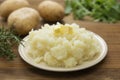 Mashed potatoes with butter and fresh white potatoes on background, wooden table. Healthy food for kids, dinner Royalty Free Stock Photo