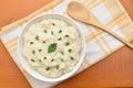 Mashed potatoes with parsley in the white bowl, wooden spoon and dish cloth Royalty Free Stock Photo