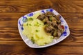 Mashed potatoes with stewed chicken liver with apple and onion on wooden table Royalty Free Stock Photo