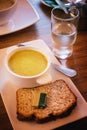 Mashed soup and bread with butter, glass of water on a dinner ta Royalty Free Stock Photo