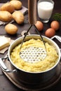 Mashing potatoes in pot on wooden table Royalty Free Stock Photo