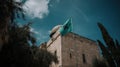 Masjid Al-Aqsa standing tall in the heart of the Old City of Jerusalem, the Palestinian flag gently waving in the breeze, a serene