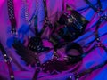 mask of a bdsm demon and leather accessories for bdsm games on a dark background in neon light