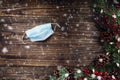 Mask and Christmas Garland over a Rustic Background Royalty Free Stock Photo