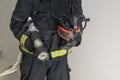 Mask and equipment in the hands of a firefighter, front view