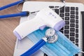 Mask, infrared thermometer and a stethoscope on the computer keyboard during coronary pneumonia Royalty Free Stock Photo