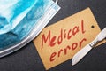 Mask, scalpel and sheet of paper with text. Medical error concept Royalty Free Stock Photo