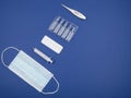 Mask, syringe, thermometer, tablets and capsules on a blue background Royalty Free Stock Photo