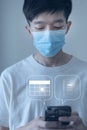 Mask weared Asian smart man use mobile smart phone to make an appointment in vitual calendar of Covid-19 vaccine