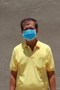 Masked Asian man prevent germs and wear yellow shirt. Tiny Particle or virus corona