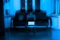 Masked burglar checking laptop in blue light