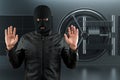 Masked burglar with crowbar in the background. Bank vault doors, large safe, bank robbery. The concept of deposit protection,