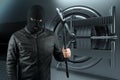 Masked burglar with crowbar in the background. Bank vault doors, large safe, bank robbery. The concept of deposit protection,